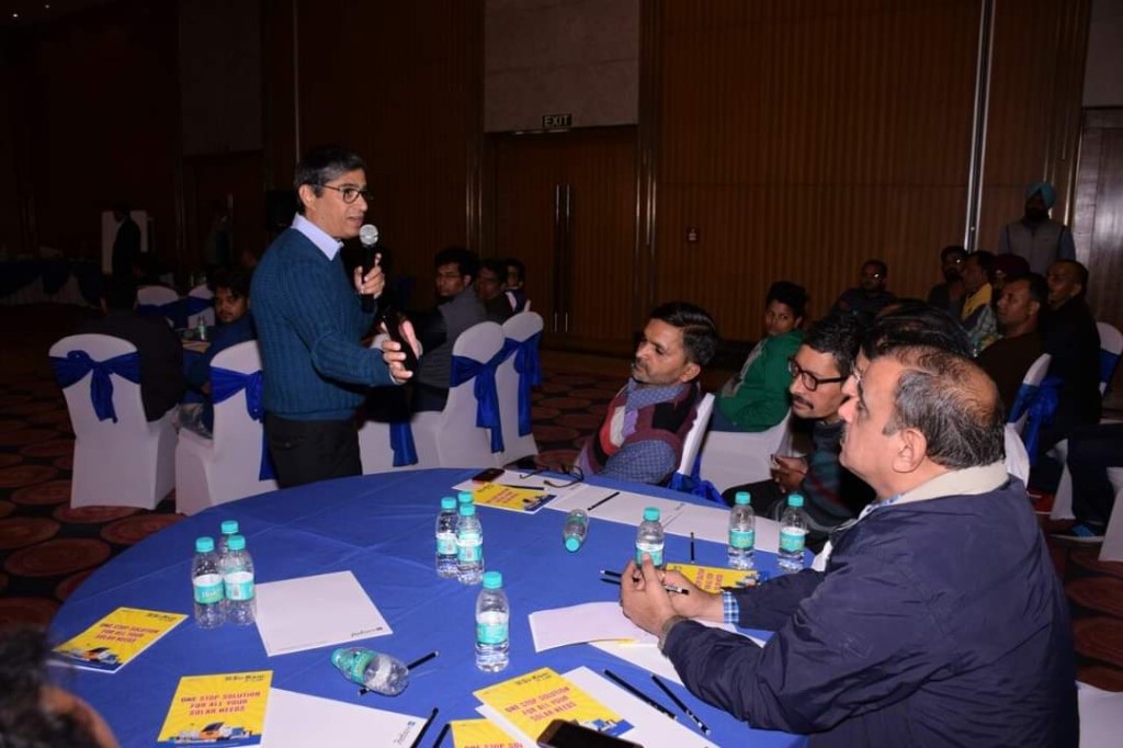 Kunwer Sachdev speaking to dealers at round tables with Su-Kam solar flyers
