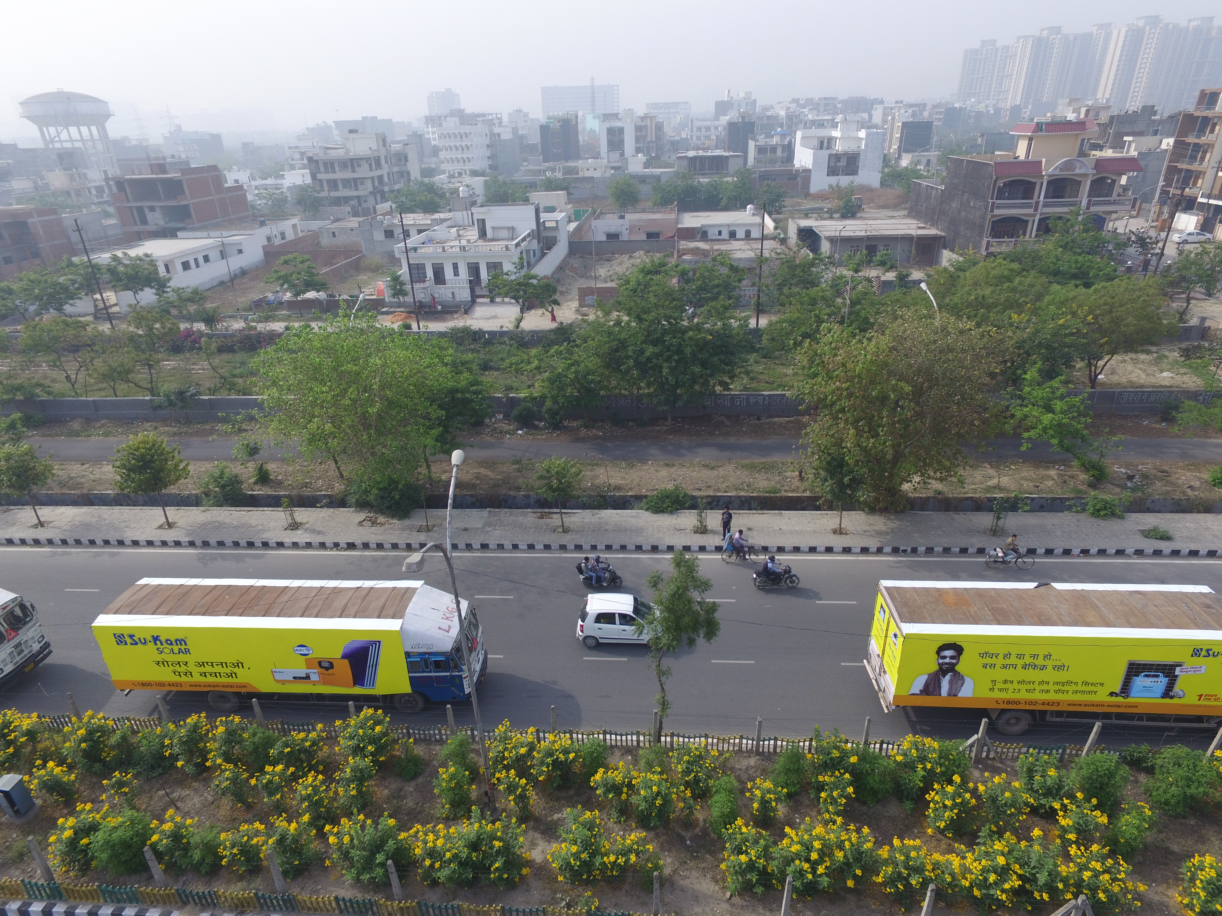 Branded trucks as moving billboards — a fleet seen from the sky.