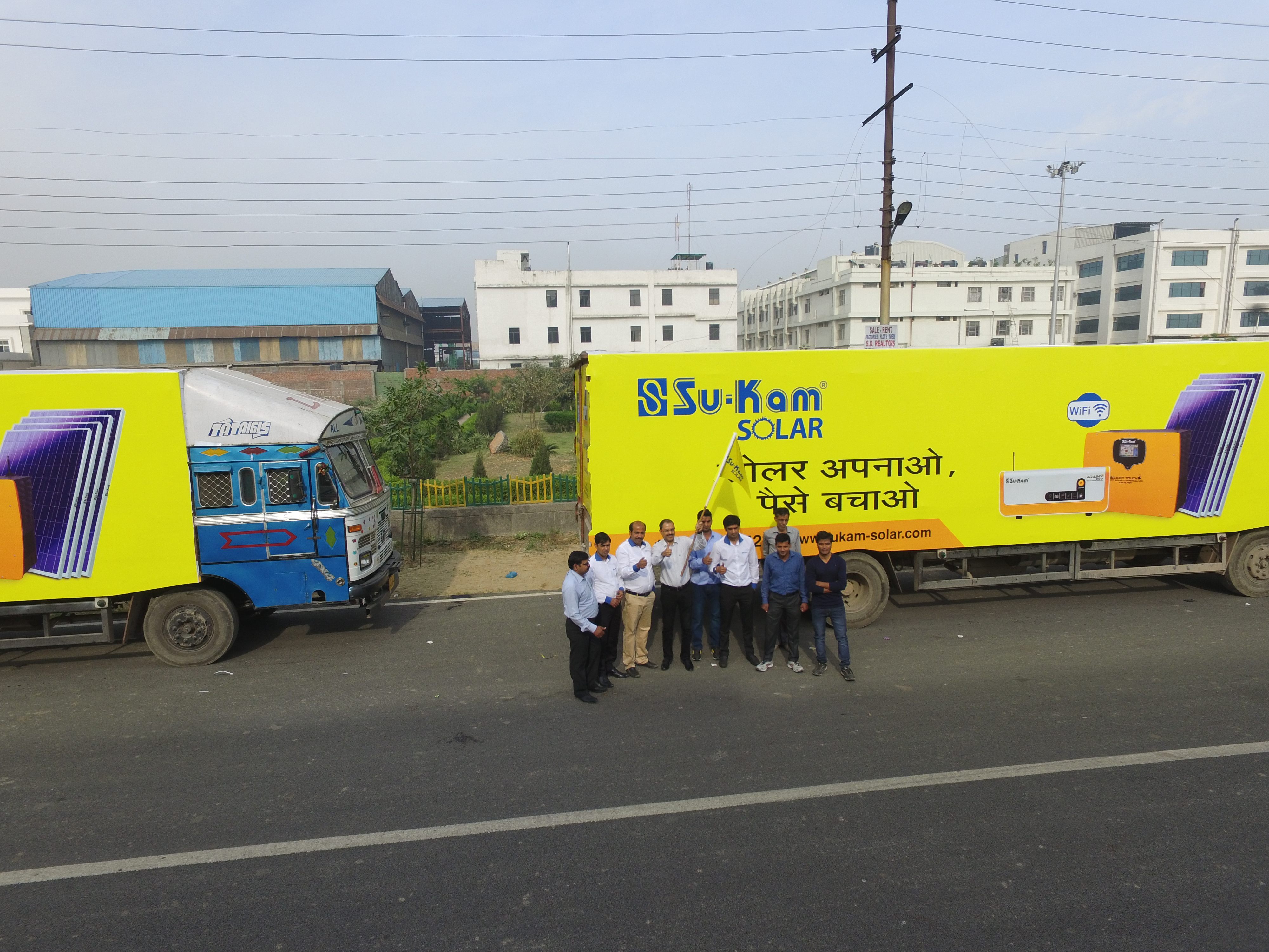 A Su-Kam Solar branded truck carrying the slogan Solar Apnao Paise Bachao, with the field marketing team in front