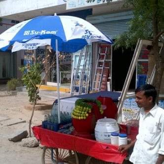 Su-Kam branded umbrellas shading street vendor carts across India