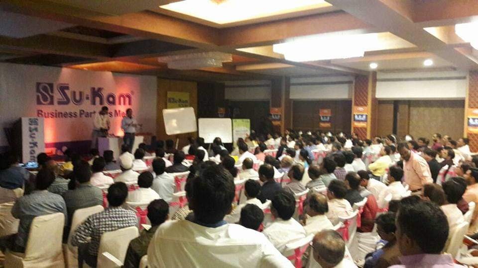 A packed dealer-meet hall — hundreds at a single event.